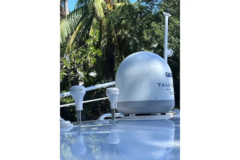 Slide: The Image of Satellite equipment on 2020 Intrepid 409 Valor boat, surrounded by tropical foliage. - 68