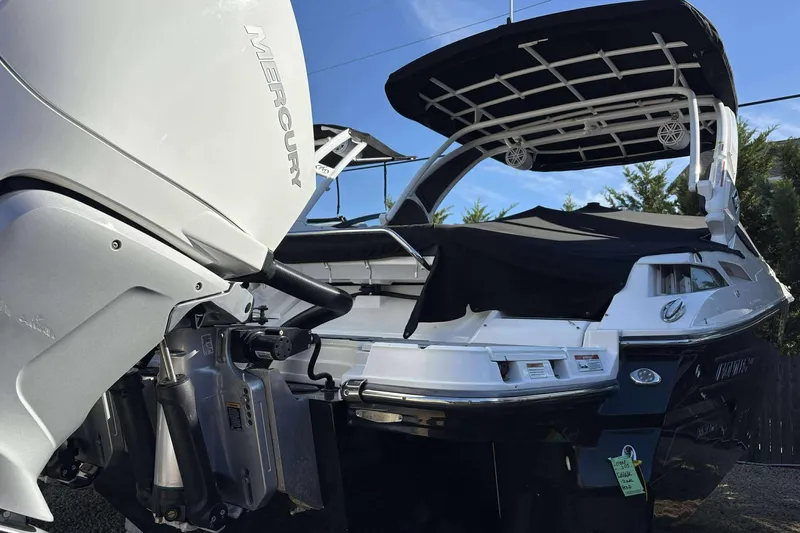 Slide: The Image of 2023 Monterey 305SS Super Sport boat with Mercury engine, rear view, black canopy. - 6