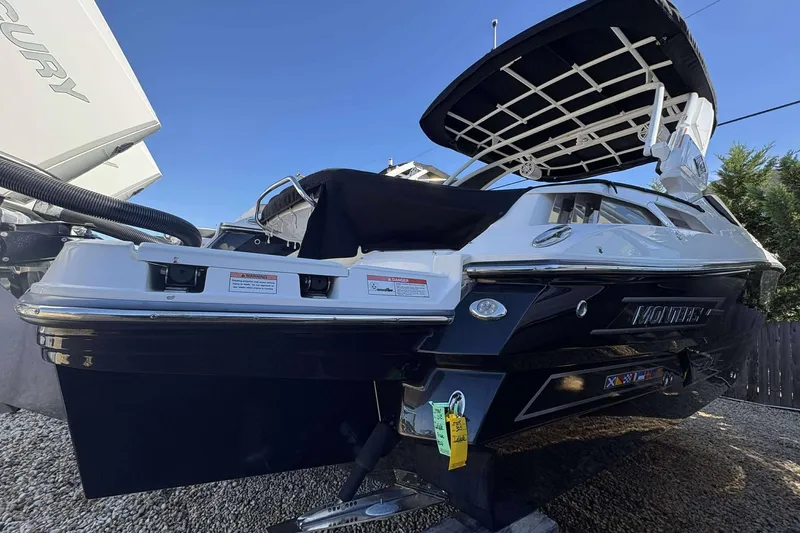 Slide: The Image of 2023 Monterey 305SS Super Sport boat with sleek black and white design, docked outdoors. - 8
