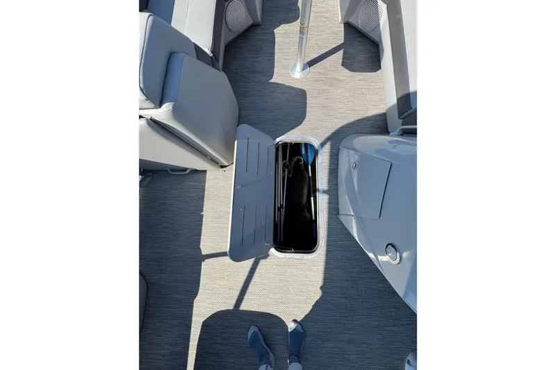 Slide: The Image of 2022 Bennington SX 23 Quad Bench interior with open storage compartment. - 14