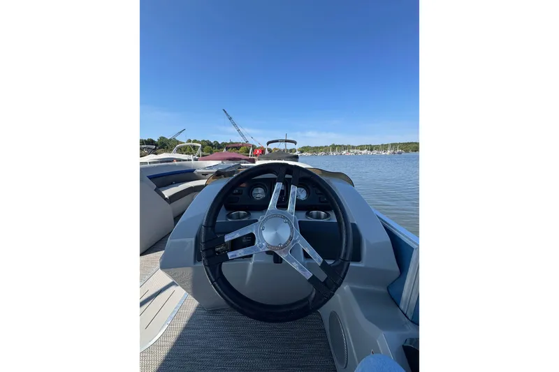 Slide: The Image of 2022 Bennington SX 23 Quad Bench boat steering wheel with scenic water view. - 17