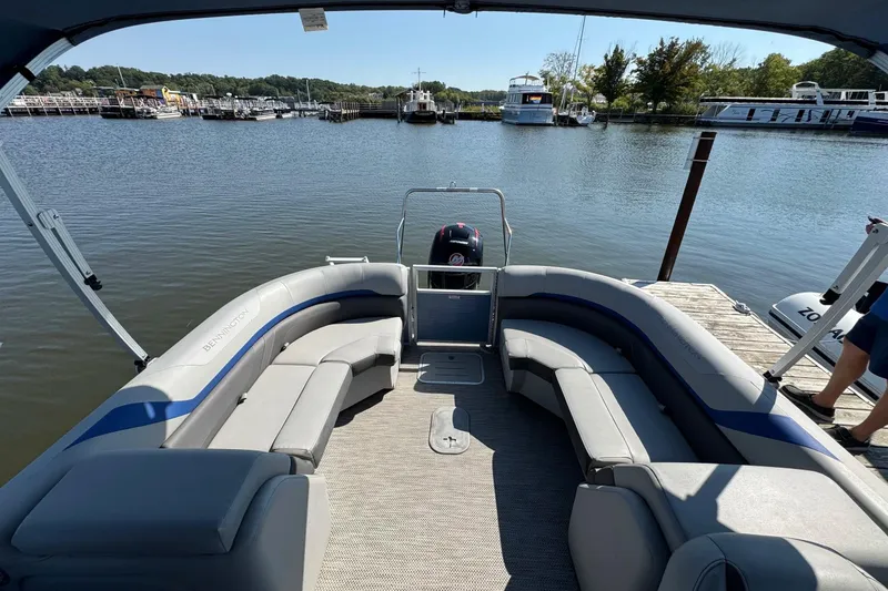 Slide: The Image of 2022 Bennington SX 23 Quad Bench pontoon boat at a marina dock. - 21