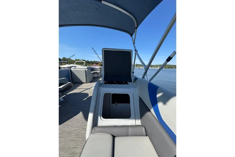 Slide: The Image of 2022 Bennington SX 23 Quad Bench pontoon boat interior with open storage compartment. - 23