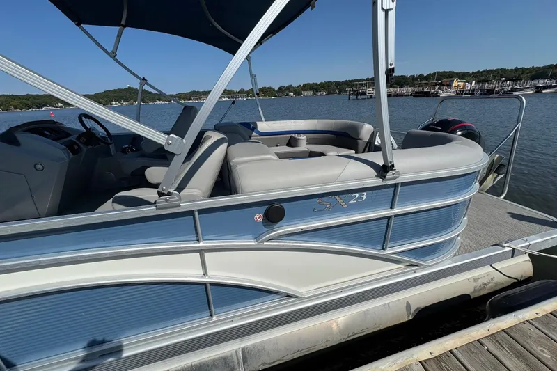Slide: The Image of 2022 Bennington SX 23 Quad Bench pontoon boat docked on a sunny day. - 26