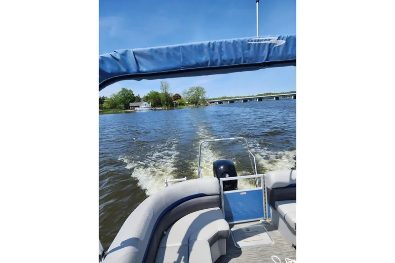 Slide: The Image of 2022 Bennington SX 23 Quad Bench pontoon boat cruising on a sunny lake. - 28