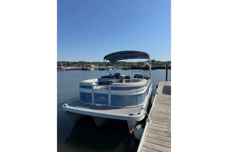 Slide: The Image of 2022 Bennington SX 23 Quad Bench pontoon boat docked on a sunny day. - 3
