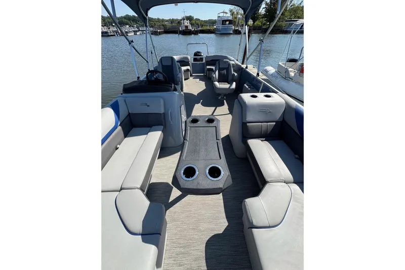 Slide: The Image of 2022 Bennington SX 23 Quad Bench interior with spacious seating and cup holders. - 7
