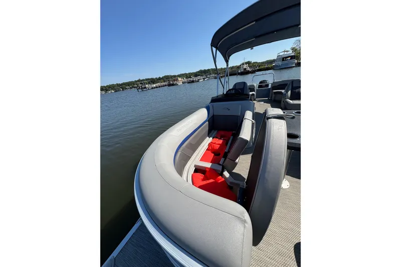Slide: The Image of 2022 Bennington SX 23 Quad Bench pontoon boat on a calm lake. - 9