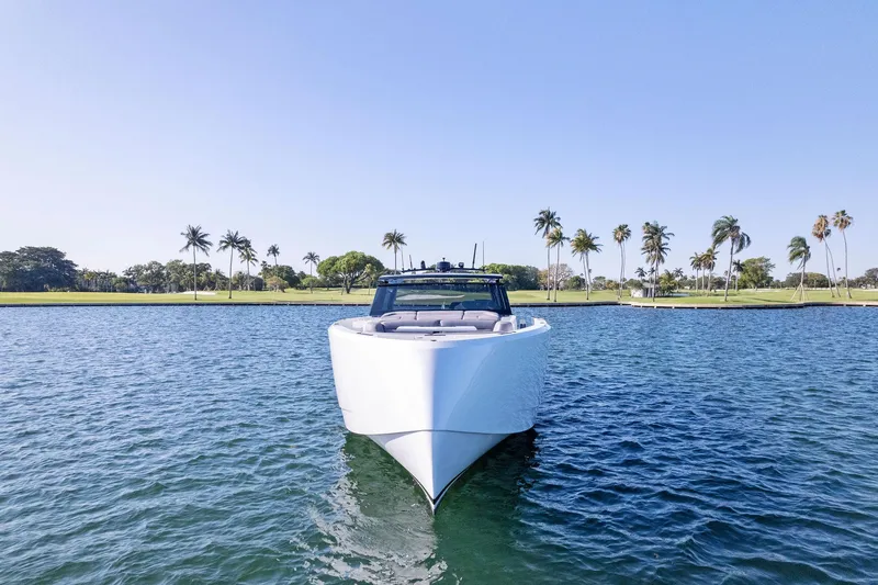 Slide: The Image of Vanquish Yachts VQ58 2022 on water, palm trees in background, clear blue sky. - 14