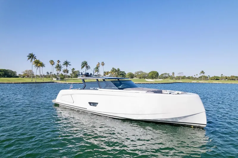 Slide: The Image of 2022 Vanquish Yachts VQ58 luxury yacht on serene water with palm trees in the background. - 18
