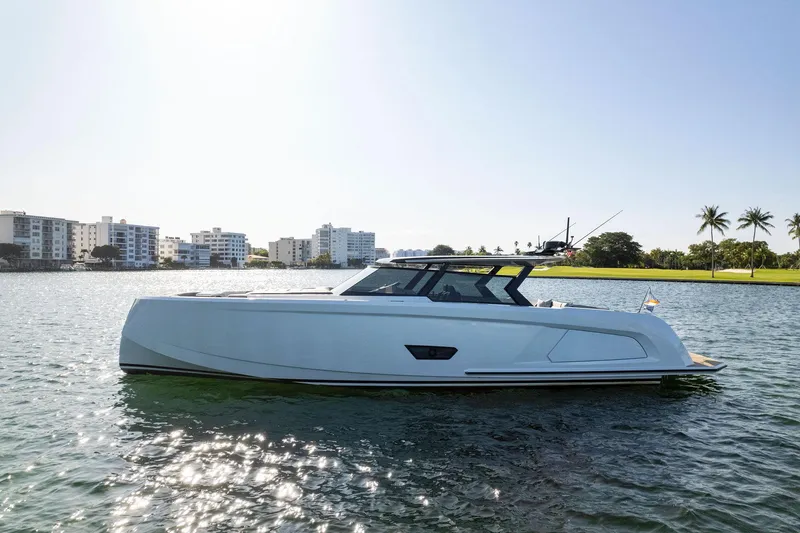 Slide: The Image of 2022 Vanquish Yachts VQ58 luxury yacht on calm water with cityscape background. - 20