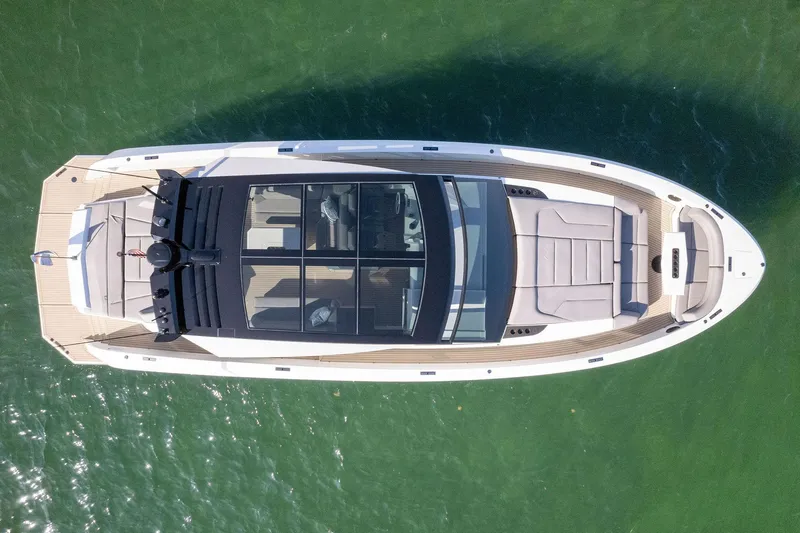 Slide: The Image of Aerial view of 2022 Vanquish Yachts VQ58 luxury yacht on green water. - 24