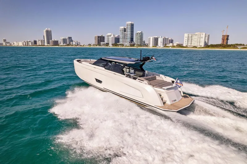 Slide: The Image of 2022 Vanquish Yachts VQ58 cruising on blue water with city skyline in background. - 31