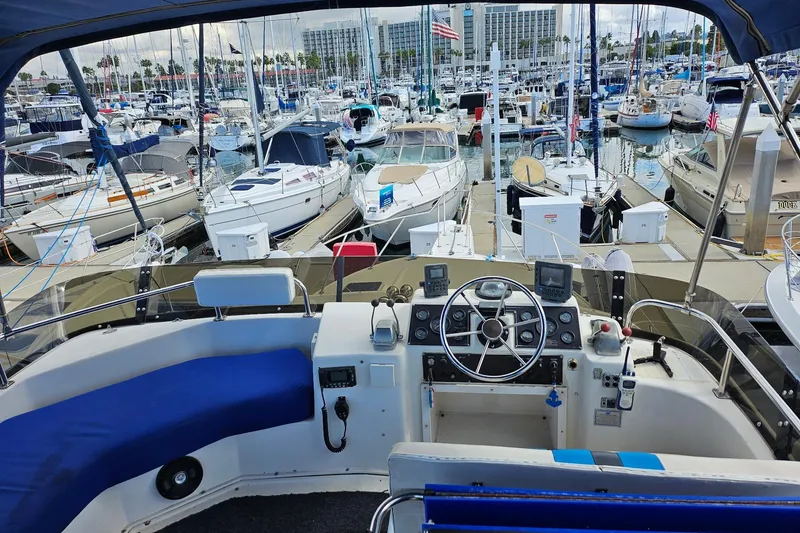 Slide: The Image of 1988 Silverton 37 Motor Yacht helm view in a busy marina. - 12