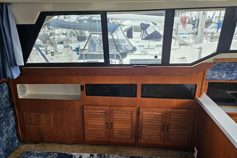Slide: The Image of Interior view of 1988 Silverton 37 Motor Yacht with wooden cabinets and marina backdrop. - 15