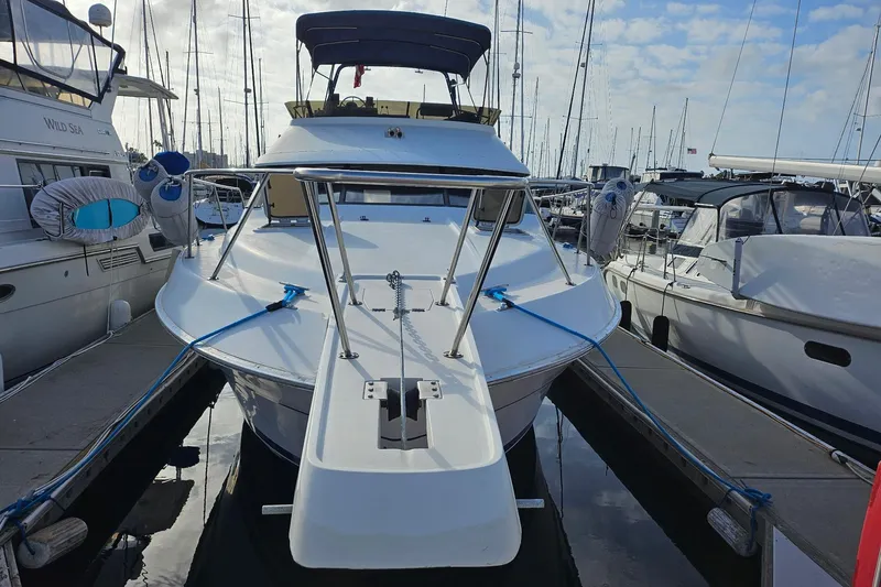Slide: The Image of 1988 Silverton 37 Motor Yacht docked at marina, surrounded by other boats. - 2