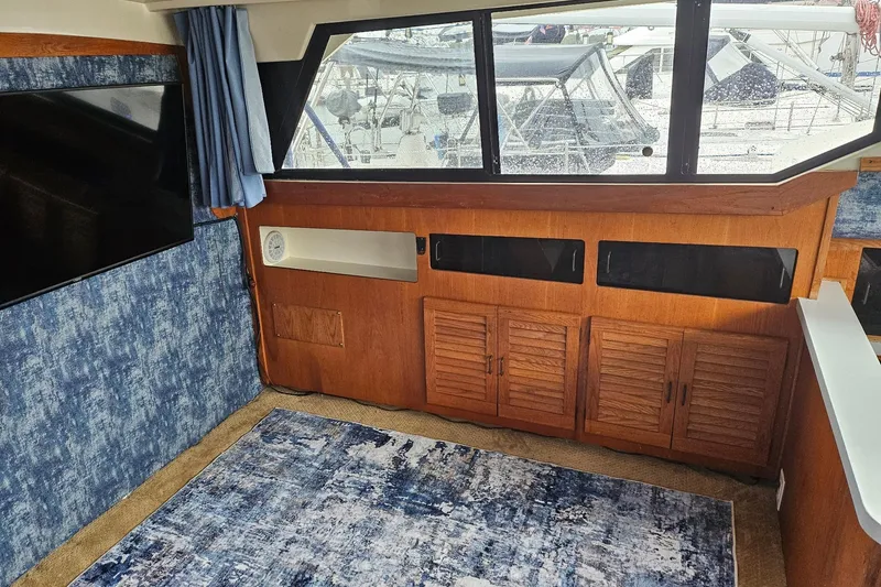Slide: The Image of Interior of 1988 Silverton 37 Motor Yacht with wood cabinets and blue decor. - 20