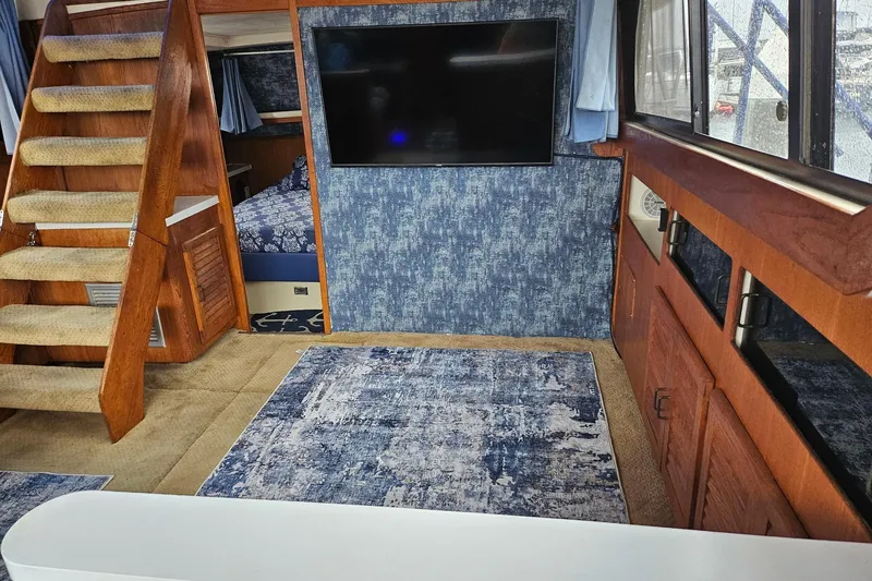 Slide: The Image of 1988 Silverton 37 Motor Yacht interior with stairs, TV, and blue decor. - 21