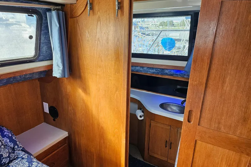 Slide: The Image of 1988 Silverton 37 Motor Yacht interior with wood paneling and compact bathroom. - 23