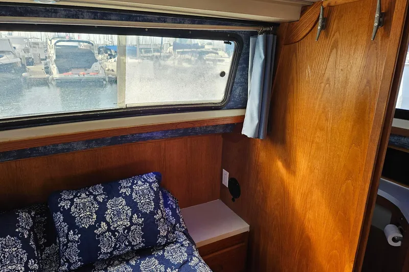 Slide: The Image of Interior of 1988 Silverton 37 Motor Yacht with wood paneling and patterned cushions. - 24