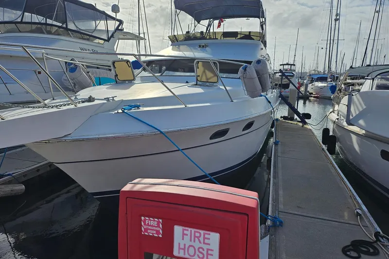 Slide: The Image of 1988 Silverton 37 Motor Yacht docked at marina with fire hose nearby. - 3