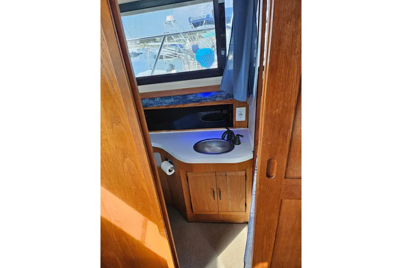 Slide: The Image of 1988 Silverton 37 Motor Yacht bathroom with wooden cabinetry and sink. - 31