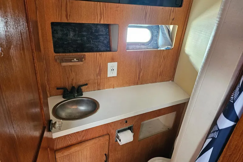 Slide: The Image of 1988 Silverton 37 Motor Yacht bathroom with wooden cabinetry and stainless steel sink. - 33