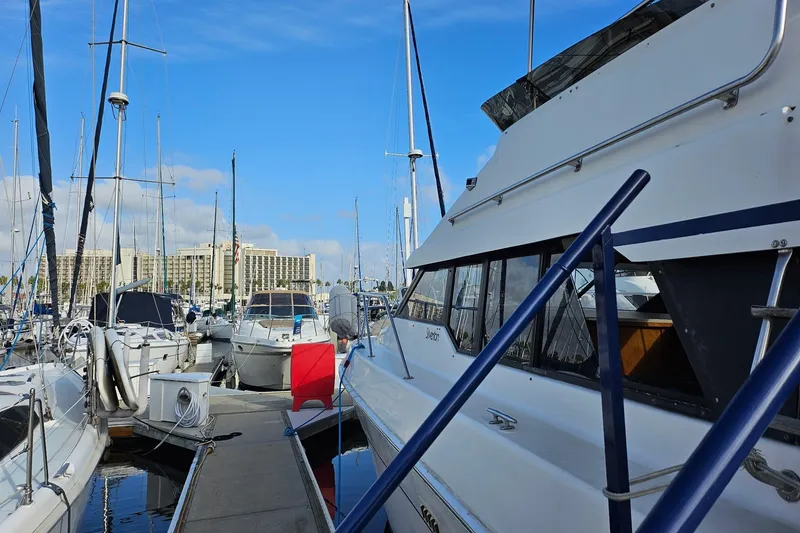 Slide: The Image of 1988 Silverton 37 Motor Yacht docked at marina with clear blue sky. - 4