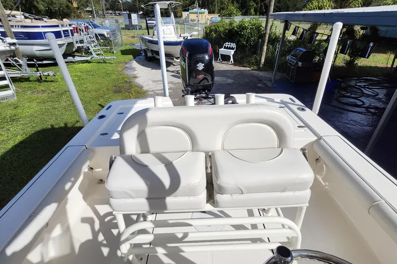 Slide: The Image of 2023 Sea Born FX22 Bay boat interior with cushioned seating and outboard motor. - 13