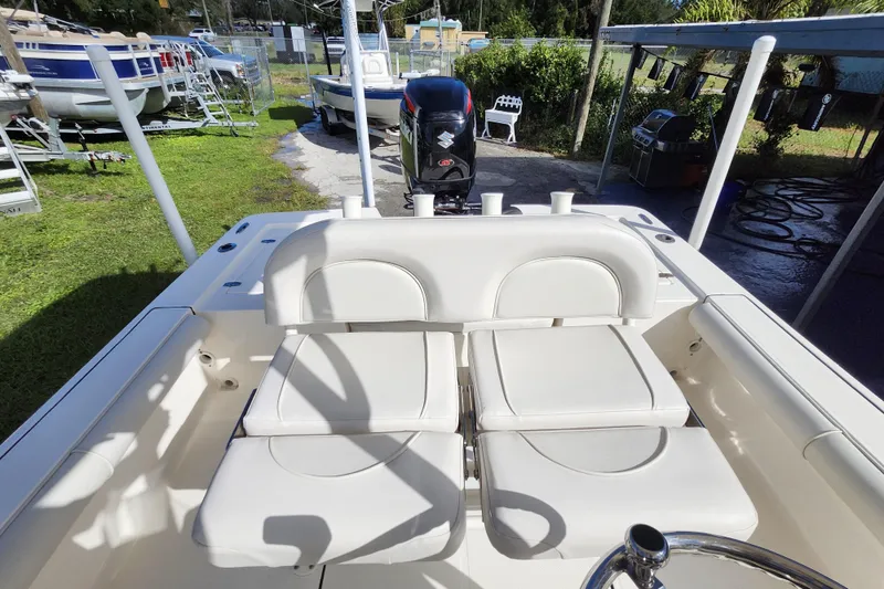 Slide: The Image of 2023 Sea Born FX22 Bay boat interior with white seating and outboard motor. - 14