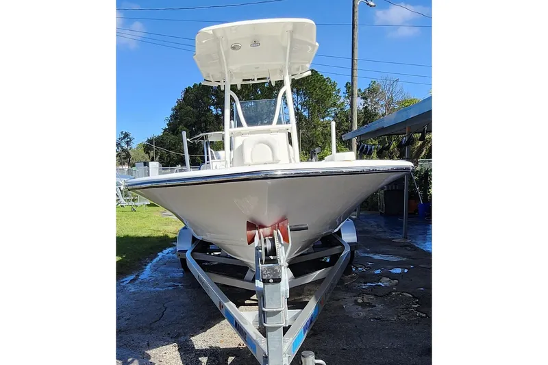 Slide: The Image of 2023 Sea Born FX22 Bay boat on trailer, parked outdoors under clear sky. - 2