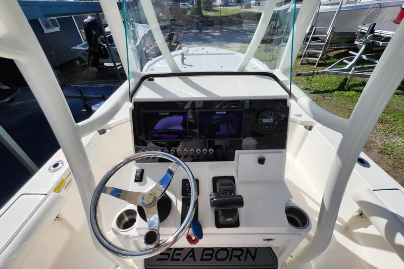 Slide: The Image of 2023 Sea Born FX22 Bay boat dashboard with steering wheel and navigation controls. - 21