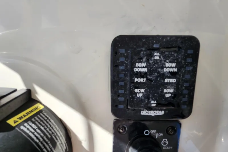 Slide: The Image of Control panel of a 2023 Sea Born FX22 Bay boat with trim tab switches. - 22