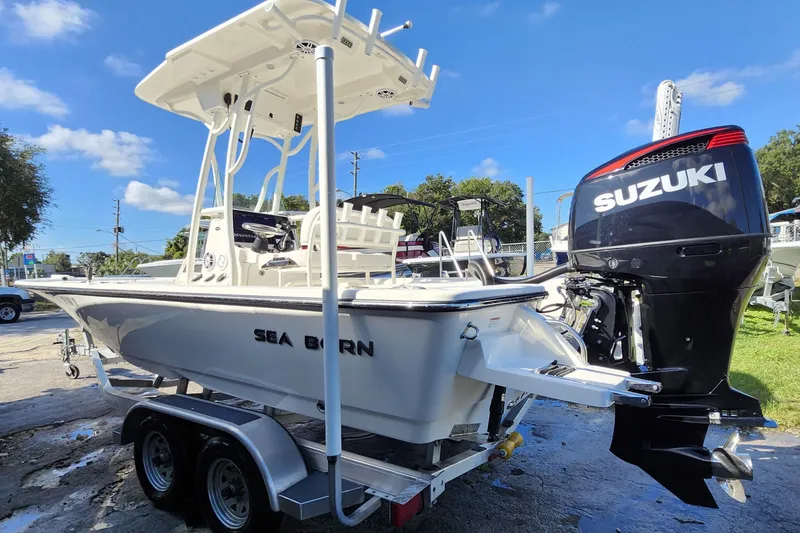 Slide: The Image of 2023 Sea Born FX22 Bay boat with Suzuki engine on trailer, under clear blue sky. - 3