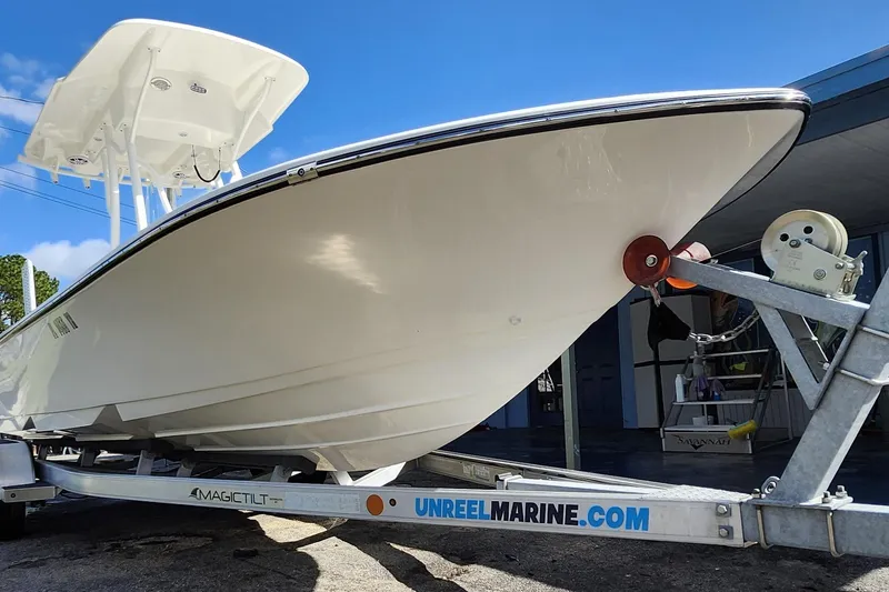 Slide: The Image of 2023 Sea Born FX22 Bay boat on trailer, under clear blue sky. - 40