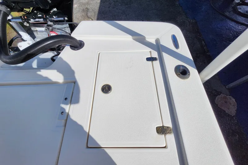 Slide: The Image of 2023 Sea Born FX22 Bay boat deck with storage compartment and motor details. - 7