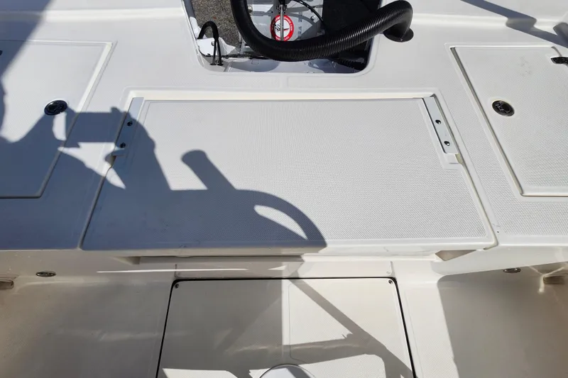 Slide: The Image of 2023 Sea Born FX22 Bay boat deck with steering wheel and storage compartments. - 9