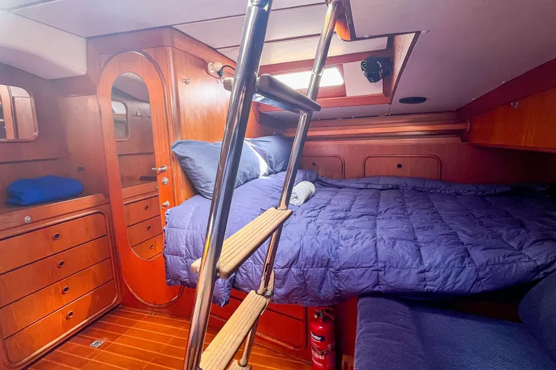 Slide: The Image of Luxurious 1991 Oyster LW48 yacht cabin with wooden interior and cozy bedding. - 10