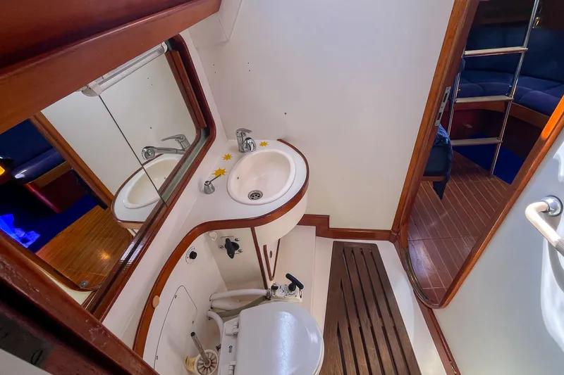 Slide: The Image of Bathroom interior of 1991 Oyster LW48 yacht with wooden accents and compact design. - 12