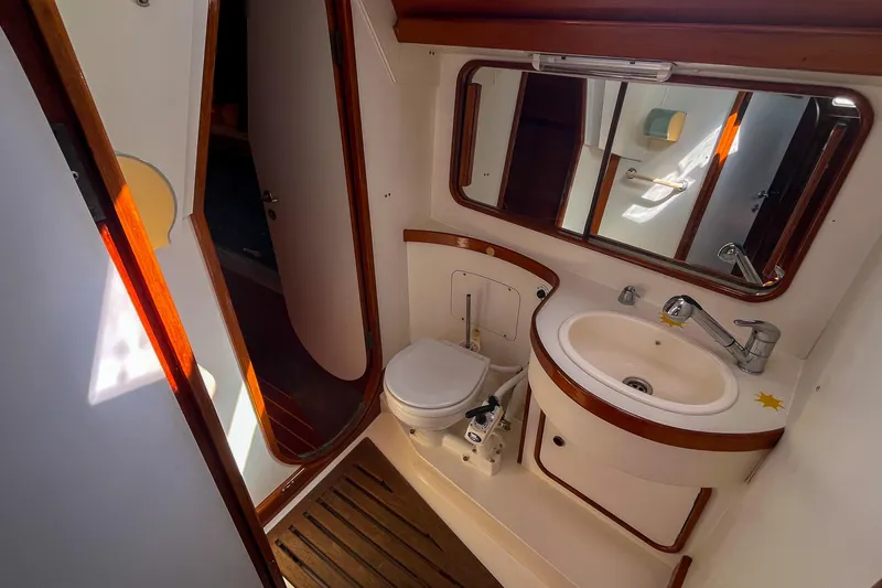 Slide: The Image of Bathroom interior of 1991 Oyster LW48 yacht with sink, toilet, and mirror. - 14