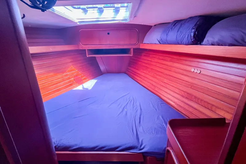 Slide: The Image of Cozy cabin interior of 1991 Oyster LW48 yacht with wooden paneling and skylight. - 16