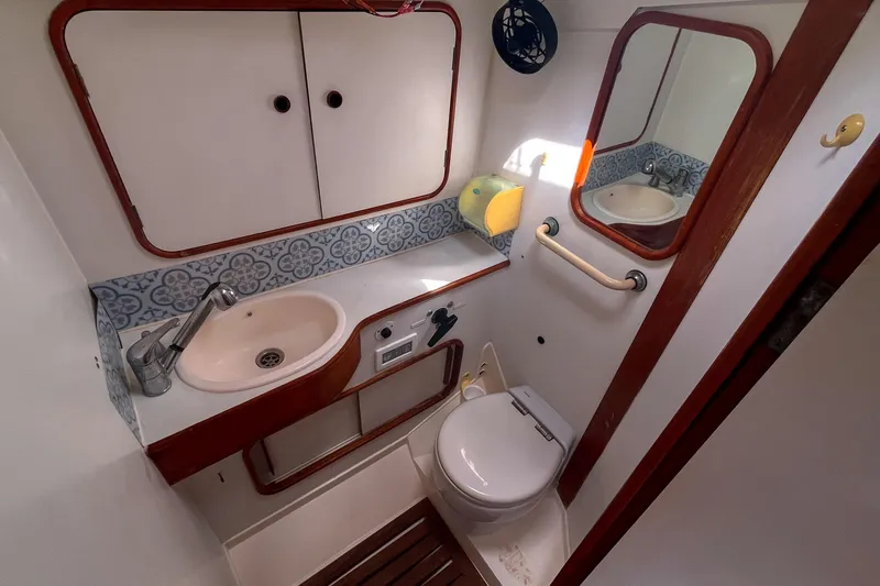 Slide: The Image of Bathroom interior of 1991 Oyster LW48 yacht with sink, toilet, and mirror. - 17