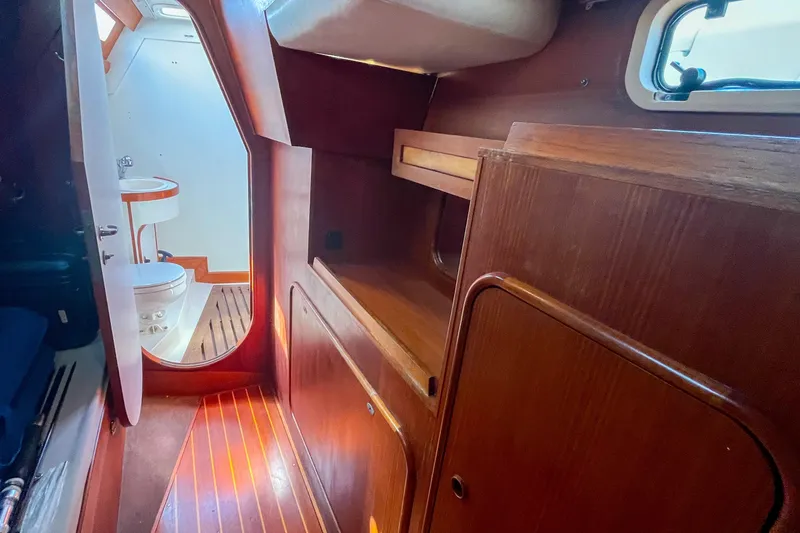 Slide: The Image of Interior of 1991 Oyster LW48 yacht with wooden cabinetry and visible bathroom. - 19