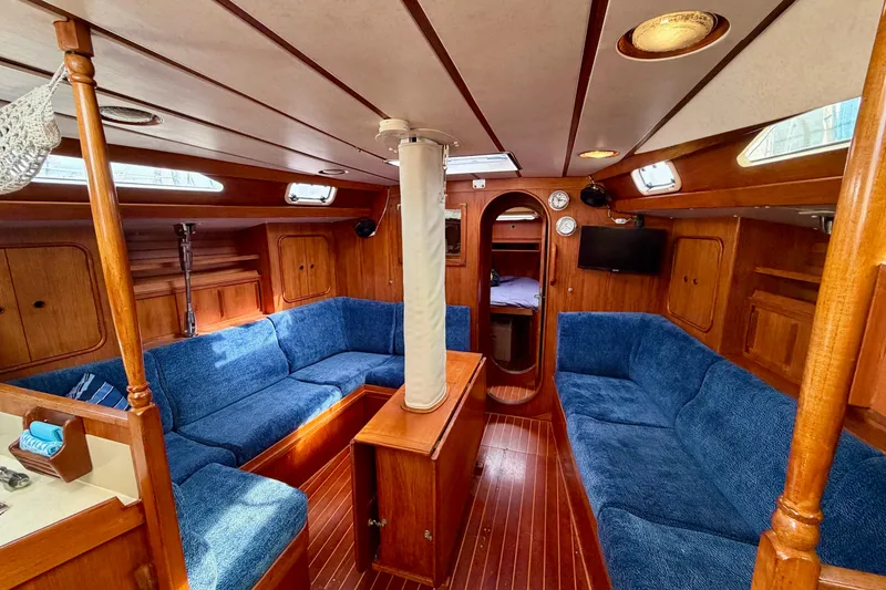 Slide: The Image of Interior of 1991 Oyster Lightwave 48 yacht with blue seating and wooden finishes. - 2