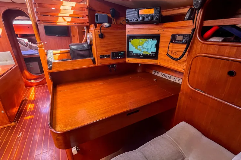 Slide: The Image of 1991 Oyster LW48 yacht interior with navigation equipment and wooden furnishings. - 23