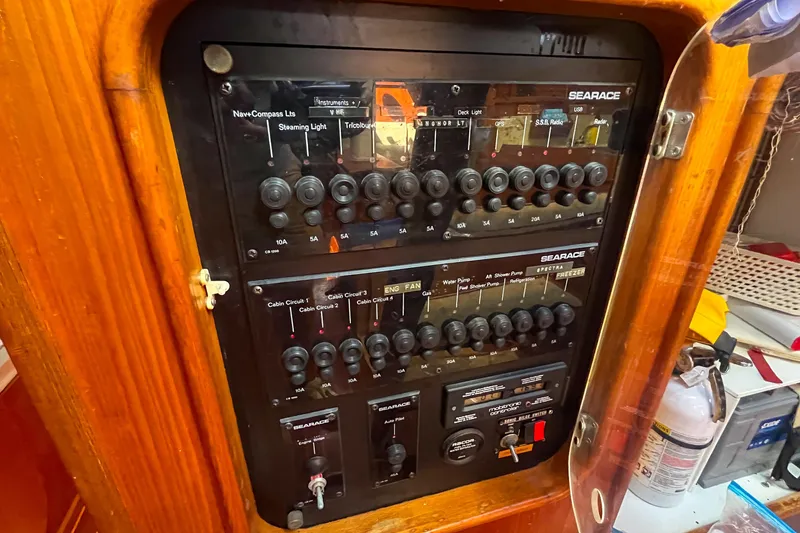 Slide: The Image of Electrical control panel on a 1991 Oyster LW48 yacht, featuring various switches and circuit breakers. - 24