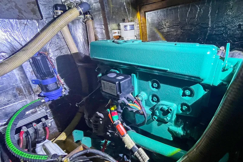 Slide: The Image of Engine room of a 1991 Oyster LW48 yacht, featuring a green engine and various components. - 26