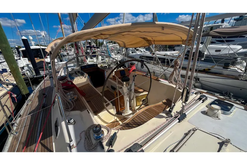 Slide: The Image of 1991 Oyster LW48 sailboat cockpit with wooden deck and steering wheel at marina. - 30