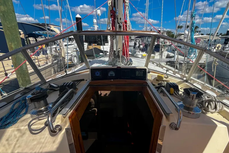 Slide: The Image of Cockpit view of 1991 Oyster LW48 sailboat docked at marina under blue sky. - 37