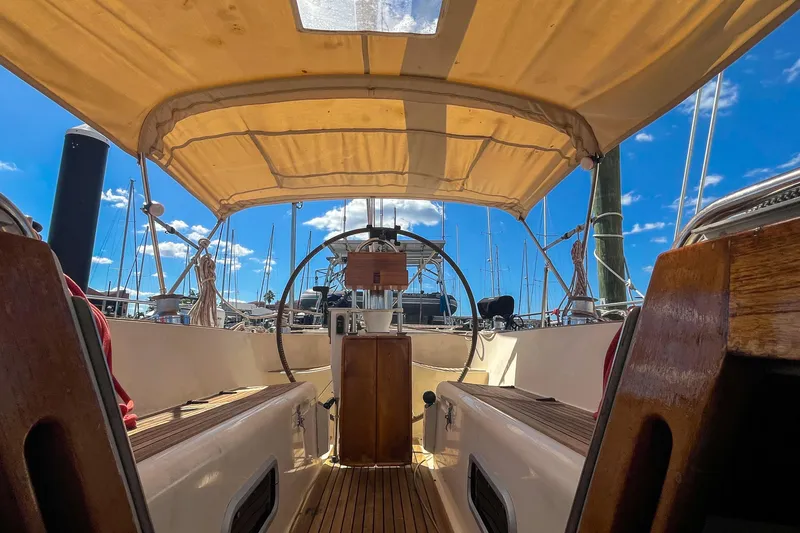 Slide: The Image of Interior view of 1991 Oyster LW48 sailboat cockpit with wooden accents and canopy. - 39